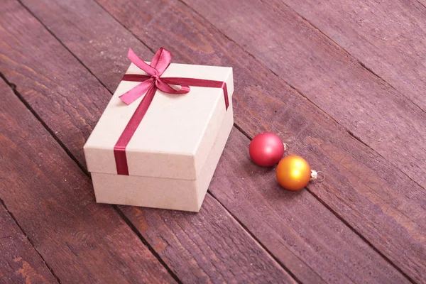 Подарочные коробки с луком и рождественские украшения на деревянном фоне — стоковое фото