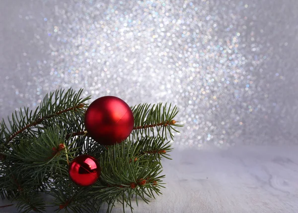 Fond décoratif avec des branches de sapin et des boules rouges sur l'argent. Carte de Noël Holiday Concept — Photo