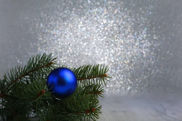 Dekorativer Hintergrund mit Tannenzweigen und blauen Kugeln auf dem Silber. Weihnachtskarten-Urlaubskonzept — Stockfoto