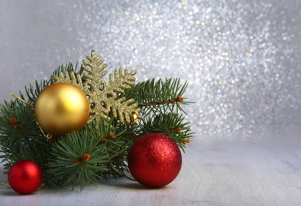 Decoratieve achtergrond met spar takken en rode ballen op het zilver. Kerstkaart Concept van de vakantie — Stockfoto