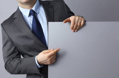 Gri arka plan üzerinde boş bir ayakta tutan işadamı