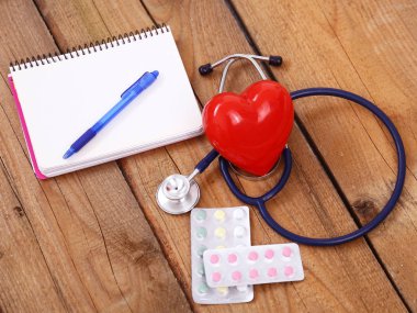 Kalp üzerinde ahşap arka plan izole bir sağlık stetoskop ile