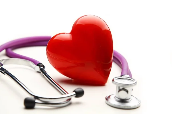 Heart with a medical stethoscope, isolated on wooden background — Stock Photo, Image