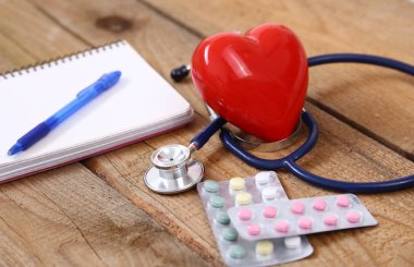 Kalp üzerinde ahşap arka plan izole bir sağlık stetoskop ile