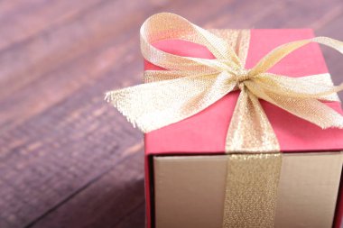Ahşap arka plan üzerinde fiyonklu hediye kutuları