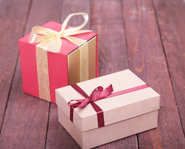 Cajas de regalo con lazo sobre fondo de madera — Foto de Stock