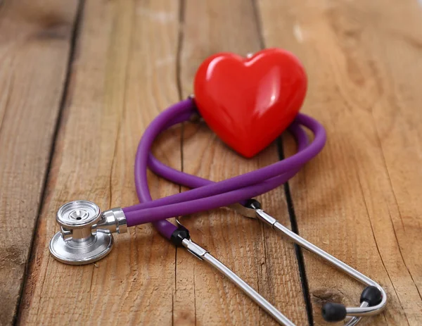 Serca stetoskopem medycznych, na białym tle na podłoże drewniane — Zdjęcie stockowe