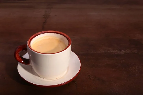 Una taza de café expreso sobre un fondo de madera oscura — Foto de Stock