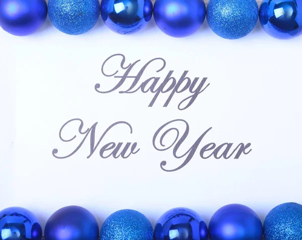 Текст с Новым годом на бумаге с большим количеством мячей — стоковое фото
