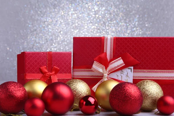 Cadeaux rouges colorés avec des boules de Noël isolées sur fond argenté — Photo