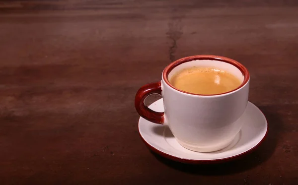 Una taza de café expreso sobre un fondo de madera oscura — Foto de Stock