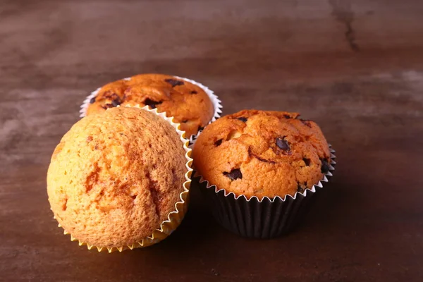 Leckere Schokoladen-Cupcakes, Muffins auf einem weißen Holztisch — Stockfoto