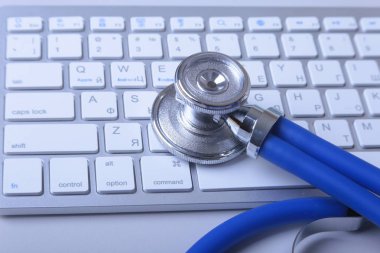 Ahşap bir masa üstünde a laptop yakınındaki tıbbi bir stetoskop