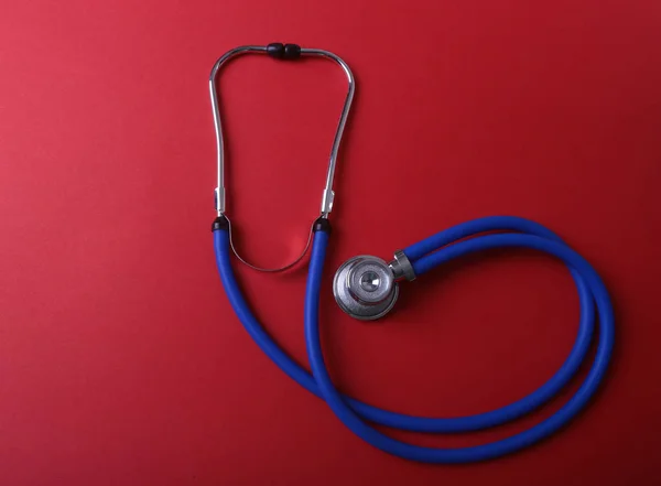 Medical blue stethoscope isolated on red background — Stock Photo, Image