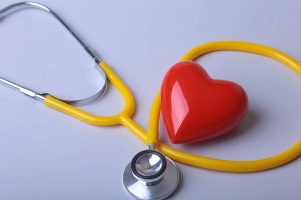 Red heart and a medical stethoscope on desk — Stock Photo, Image