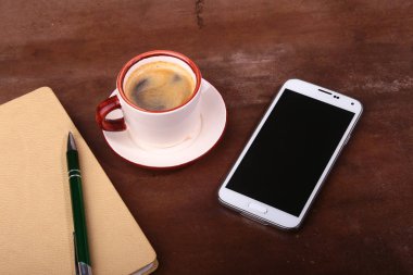 Boş defter ve topu kalem bir fincan kahve, Ofis Büro telefon ile. İş kavramı