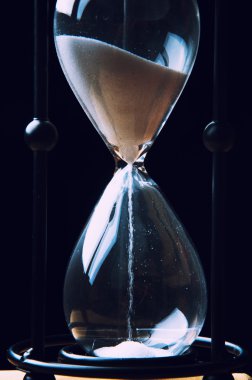 Koyu arka plan üzerinde kum saati. Yakın çekim