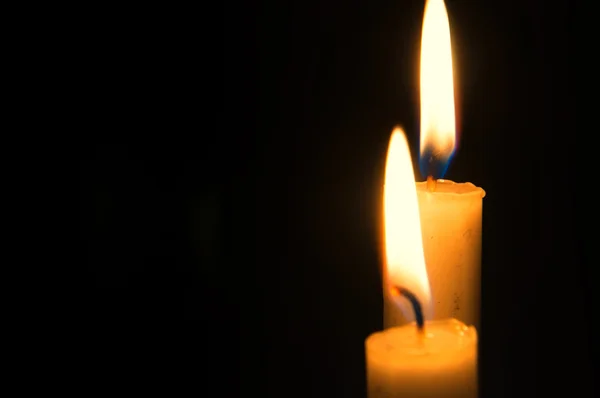 Dos velas encendidas sobre fondo negro. Espacio de copia Fotos De Stock