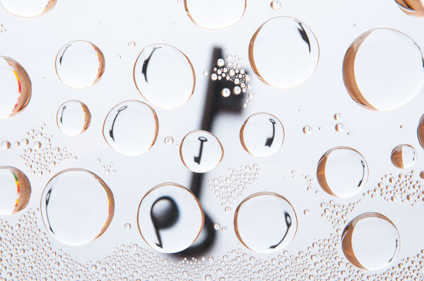 Старый ключ за каплями воды. Абстрактный фон
