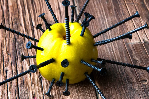 Grönt äpple punkteras med naglar — Stockfoto