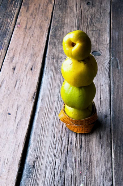 Stapel von Äpfeln mit Maßband umwickelt Schneider. Holzuntergrund. Kopierraum — Stockfoto