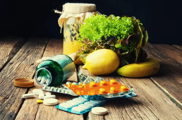 Wahl zwischen Vitaminen aus Nahrungsergänzungsmitteln oder aus Gemüse und Obst — Stockfoto