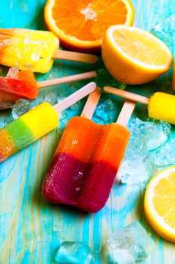 Renkli Buz lolly ve mavi ahşap zemin üzerine friuts