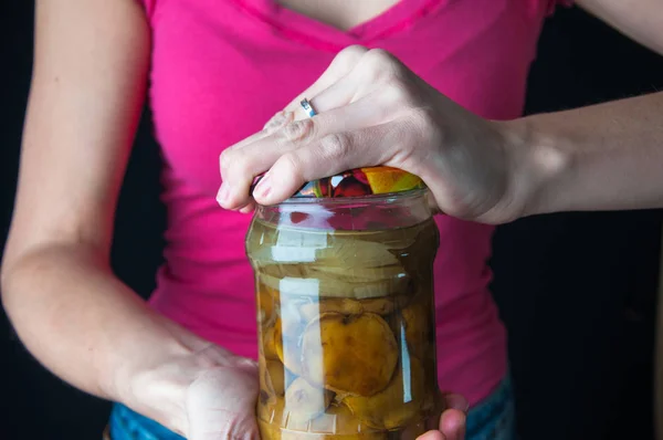 Bir kavanoz açmaya çalışan bir kadına