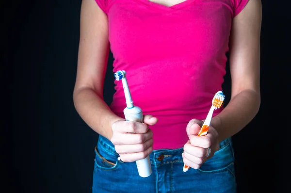 Kadın arasında geleneksel ve elektrikli diş fırçası seçme