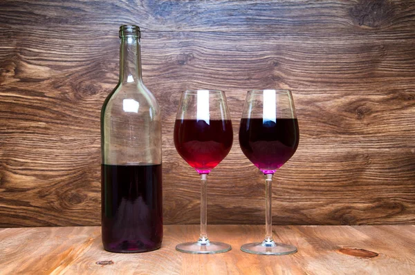 Wine glass and bottle on a wooden background — Stock Photo, Image