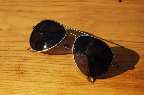 Closeup of aviator sunglasses on a wooden table — Stock Photo, Image