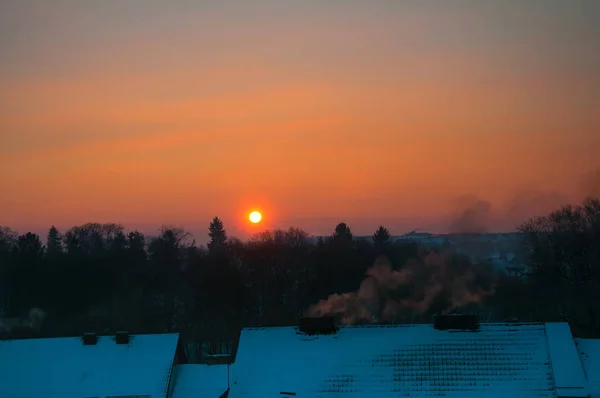 Techos cubiertos de nieve al atardecer — Foto de Stock