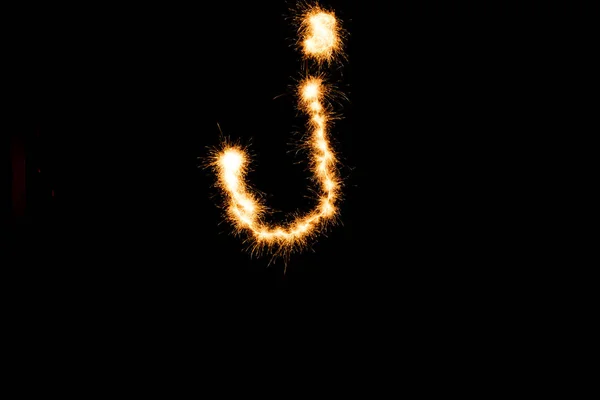 English alphabet from yellow sparkler on black background — Stock Photo, Image