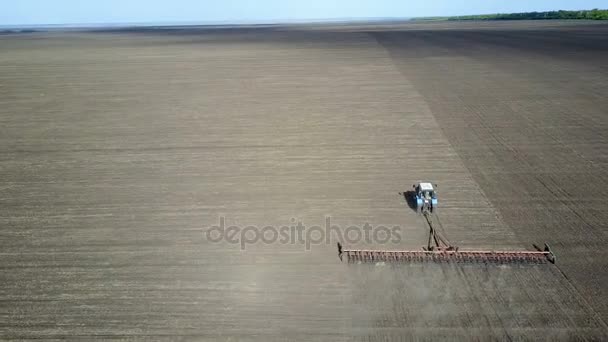 Хороший фермер бороны свое поле на тракторе — стоковое видео
