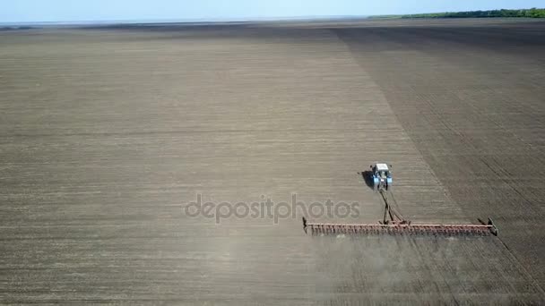 Um bom fazendeiro entranha seu campo no trator — Vídeo de Stock