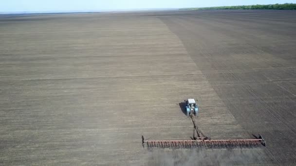 A good farmer harrows his field on the tractor — Stock Video