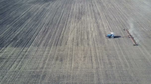 A good farmer harrows his field on the tractor — Stock Video