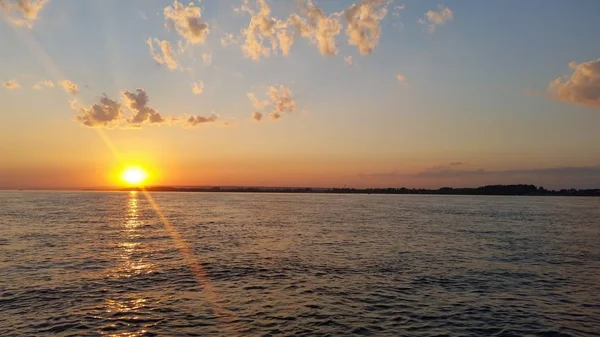 Prachtige zonsondergang zonsondergang op een rivier met wolken — Stockfoto