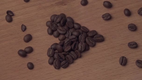 Granos de café en forma de corazón giran en una pizarra — Vídeos de Stock