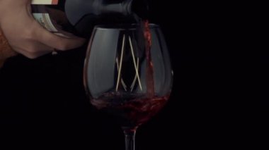 Şarap şişeden bardağa ağır çekimde akıyor.
