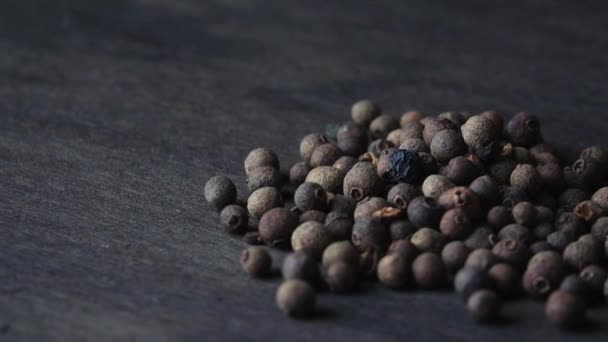 Peppers of black pepper spin on a board — Stock Video