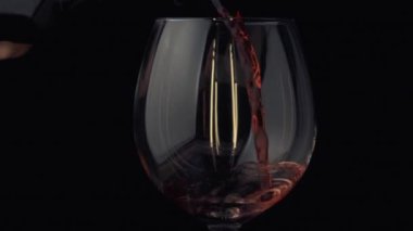 Şarap şişeden bardağa ağır çekimde akıyor.