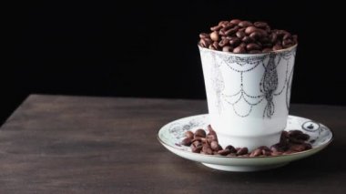 Kahve taneleriyle dolu tabak ve çay tabağı.