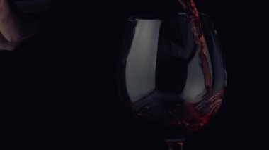 Şarap şişeden bardağa ağır çekimde akıyor.