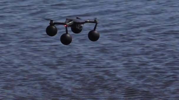 Quadcopter in slow motion zwevend boven water — Stockvideo