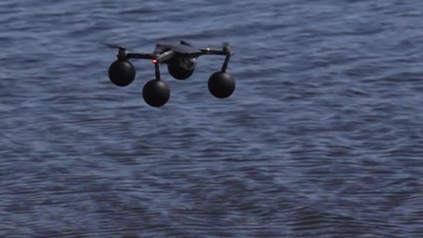 Quadcopter in slow motion hovering over water — Stock Video