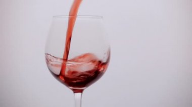 Şarabı ağır çekimde bardağa doldurur.