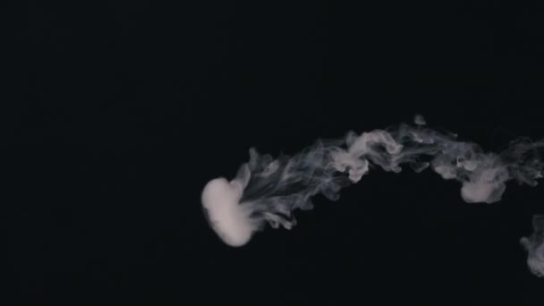 souffle des anneaux de fumée sur un fond noir 