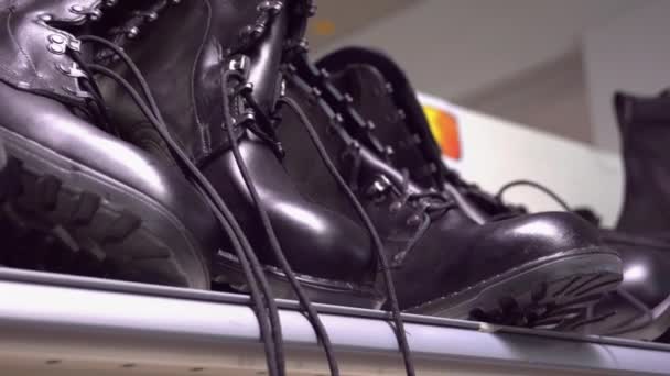 架子上的黑色军用靴子 — 图库视频影像