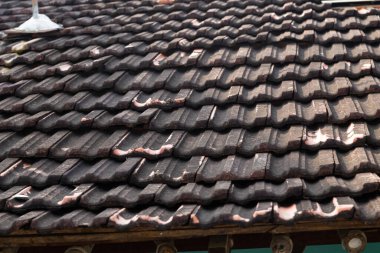 Evin çatısında eski kahverengi fayanslar, eski bir ev çatısı, çatı inşa etmek için geleneksel etnik malzemeler.